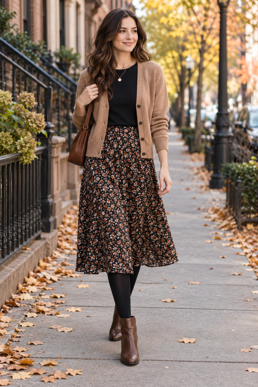 Camel cardigan and dark top with a printed midi skirt, opaque tights, and ankle boots for a fall outfit